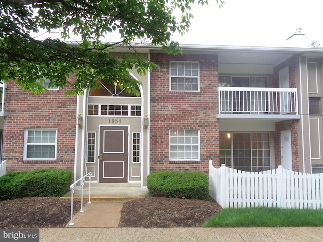 view of front of home with brick siding and fence