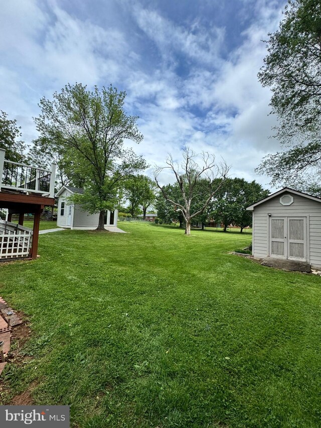 view of yard featuring a deck, an outbuilding, and a storage unit