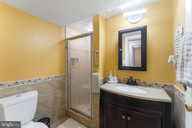 7703 Huron Dr, Gainesville, VA 20155 - bathroom with tile walls, vanity, toilet, a stall shower, and wainscoting