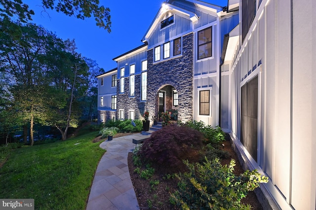 3015 Friends Rd, Annapolis, MD 21401 - view of exterior entry with stone siding, board and batten siding, and a yard