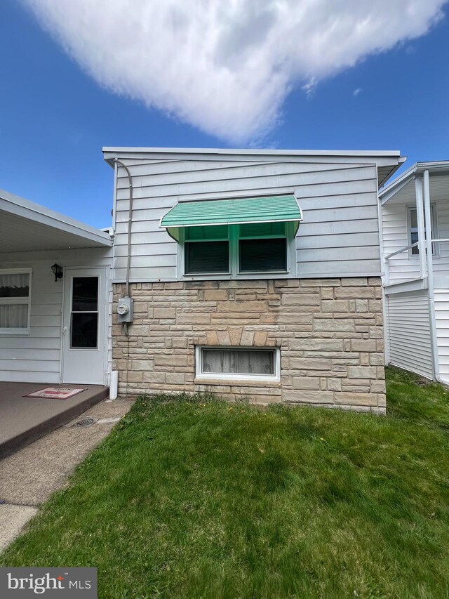1228 Spruce St, Ashland, PA 17921 - back of property with stone siding and a lawn