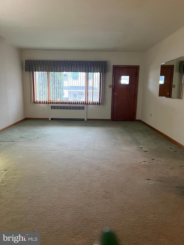 1228 Spruce St, Ashland, PA 17921 - unfurnished living room featuring radiator, baseboards, carpet flooring, and a healthy amount of sunlight