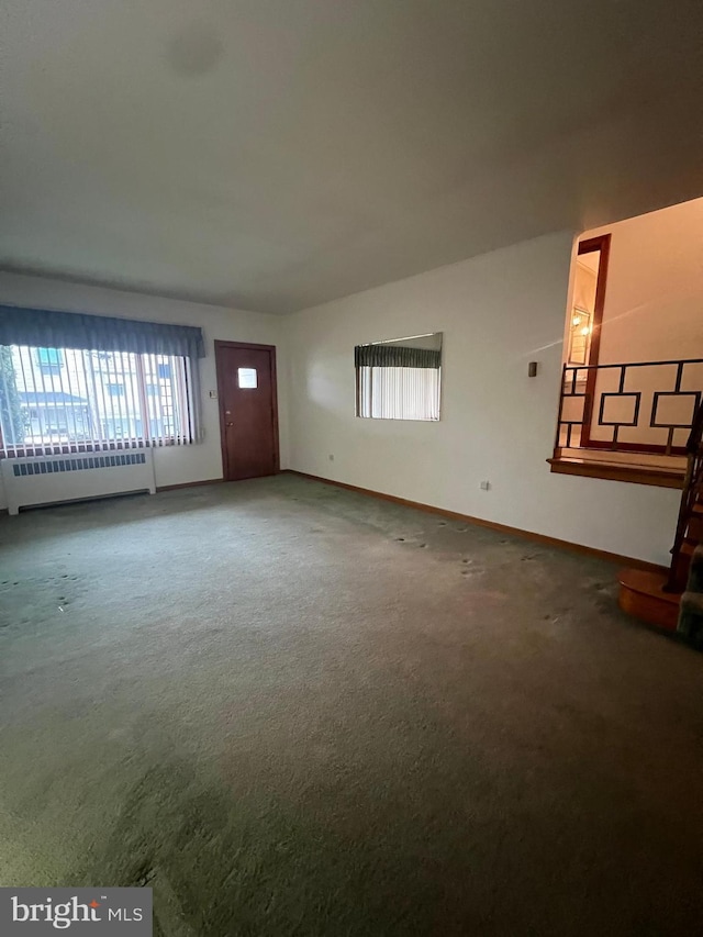 1228 Spruce St, Ashland, PA 17921 - unfurnished living room featuring baseboards, radiator heating unit, and carpet floors
