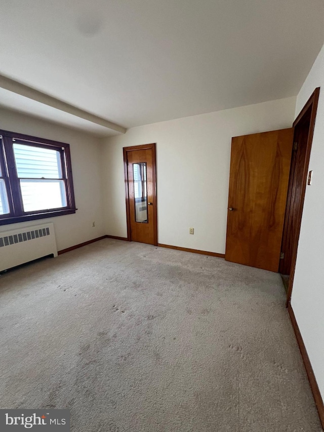 1228 Spruce St, Ashland, PA 17921 - empty room featuring light carpet, radiator, baseboards, and a healthy amount of sunlight