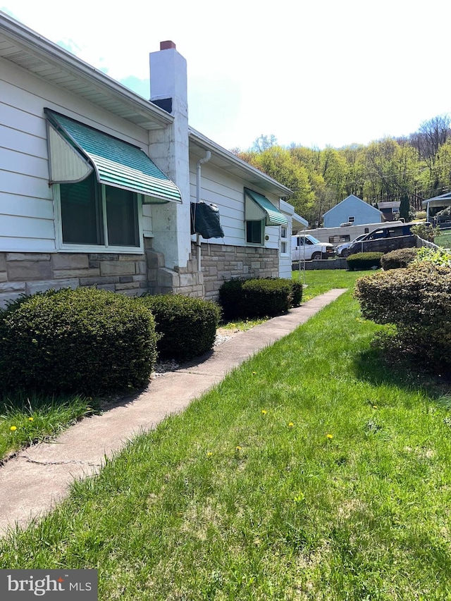 1228 Spruce St, Ashland, PA 17921 - view of home's exterior featuring stone siding, a yard, and a chimney