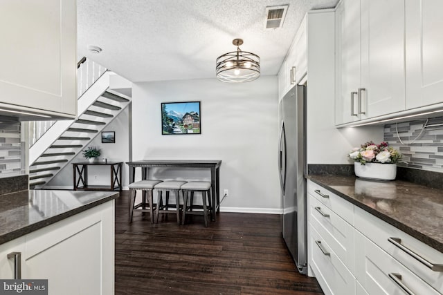 3901 Golf Tee Ct Unit 301, Fairfax, VA 22033 - kitchen with decorative backsplash, freestanding refrigerator, baseboards, dark wood-style floors, and white cabinets