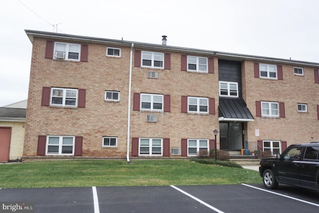 view of building exterior featuring uncovered parking and cooling unit