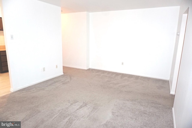 carpeted empty room with baseboards
