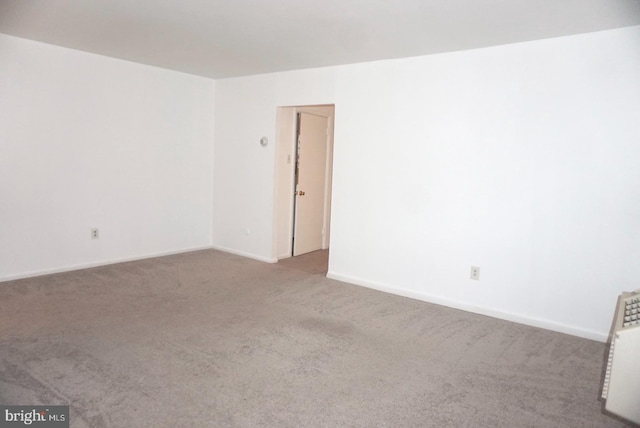 carpeted empty room with baseboards