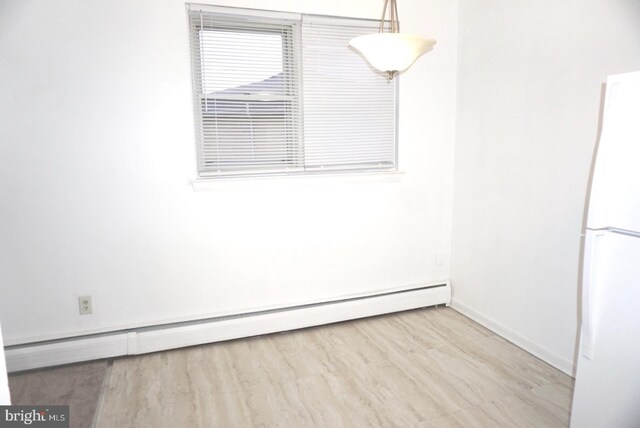 spare room with a baseboard radiator and baseboards