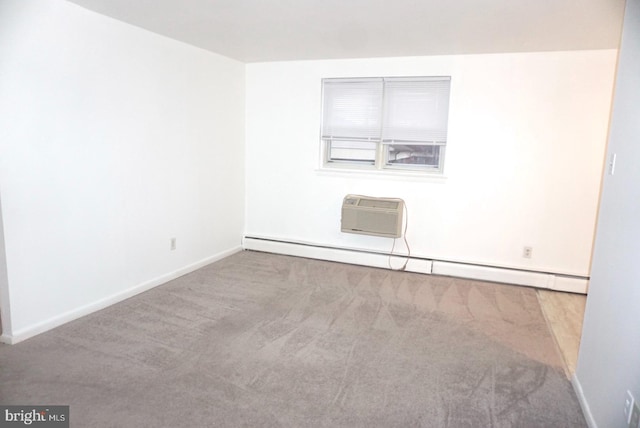 spare room with baseboard heating, carpet flooring, an AC wall unit, and baseboards