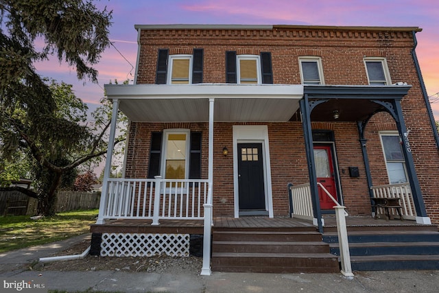 view of property with a porch and brick siding