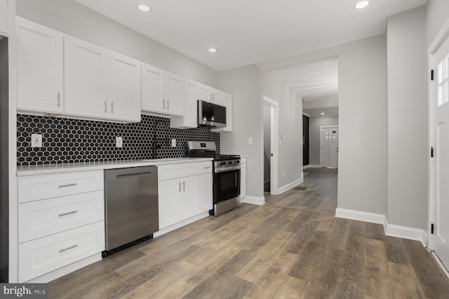 kitchen with light countertops, stainless steel appliances, white cabinets, and decorative backsplash