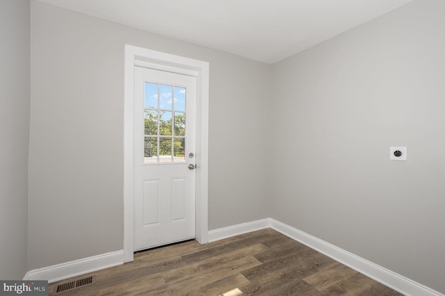 doorway to outside featuring visible vents, baseboards, and dark wood-type flooring