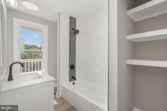 bathroom featuring baseboards, wood finished floors, shower / tub combination, and a sink
