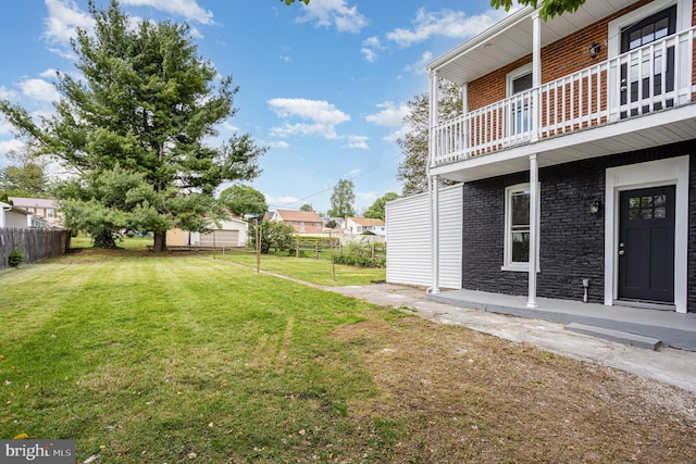 view of yard with fence and a balcony