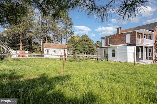 view of yard featuring a balcony and fence