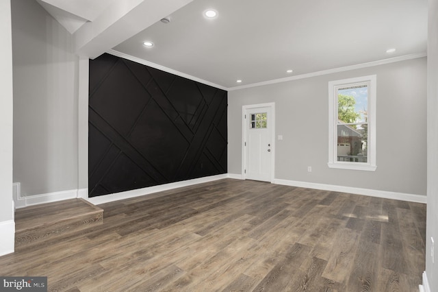 interior space with crown molding, wood finished floors, and baseboards