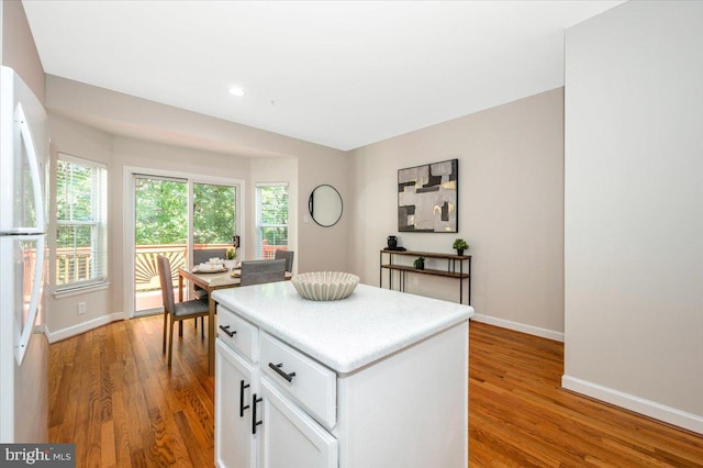 6343 Wind Rider Way, Columbia, MD 21045 - kitchen featuring freestanding refrigerator, wood finished floors, white cabinets, healthy amount of natural light, and recessed lighting