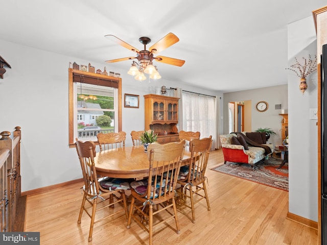 dining area featuring light wood-type flooring, baseboards, and ceiling fan