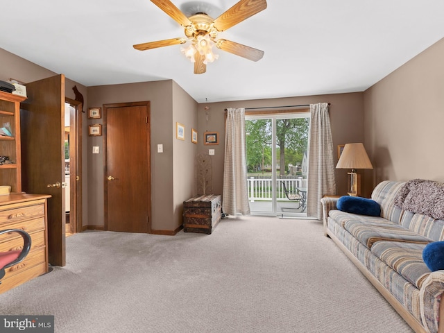 living area featuring carpet flooring, baseboards, and a ceiling fan
