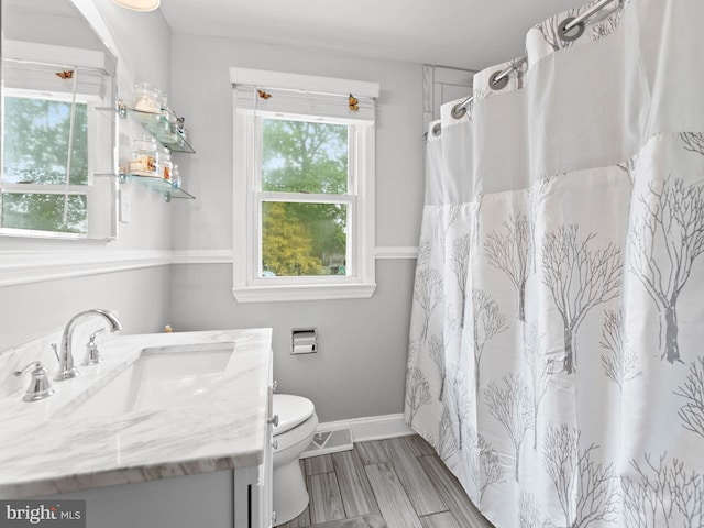 full bathroom featuring vanity, toilet, baseboards, and visible vents