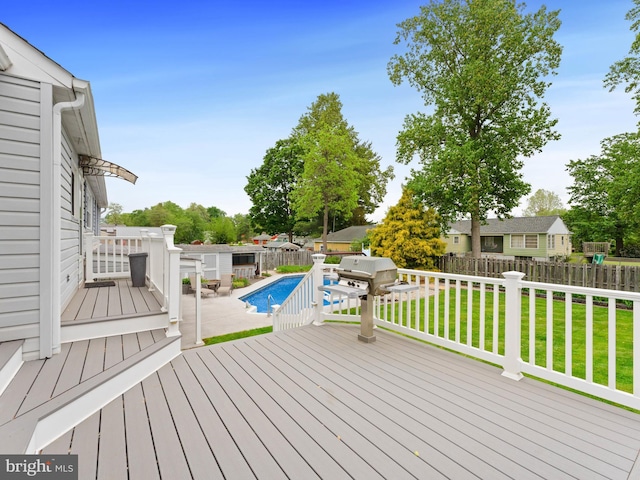 wooden deck featuring a lawn, a fenced in pool, and a fenced backyard