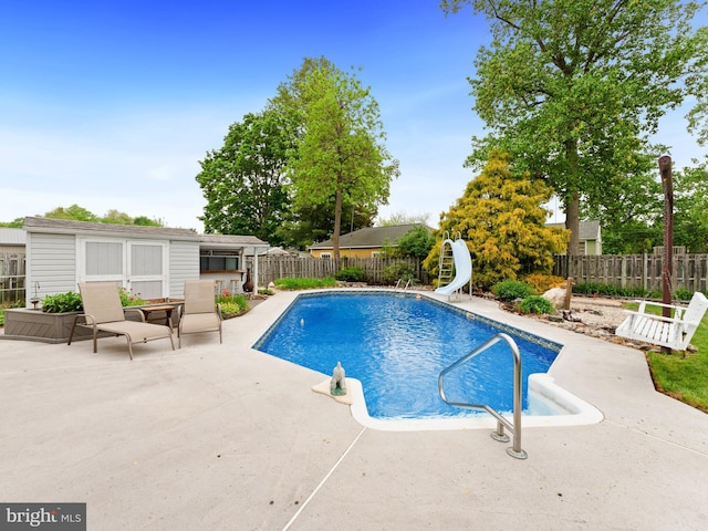 view of pool featuring a fenced backyard, a patio area, a fenced in pool, and a water slide