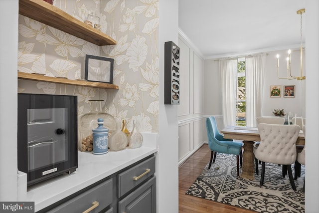 dining space featuring a chandelier, ornamental molding, and wood finished floors