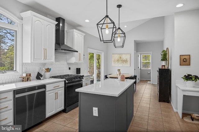 kitchen featuring light tile patterned floors, wall chimney range hood, white cabinetry, black range with gas cooktop, and dishwasher