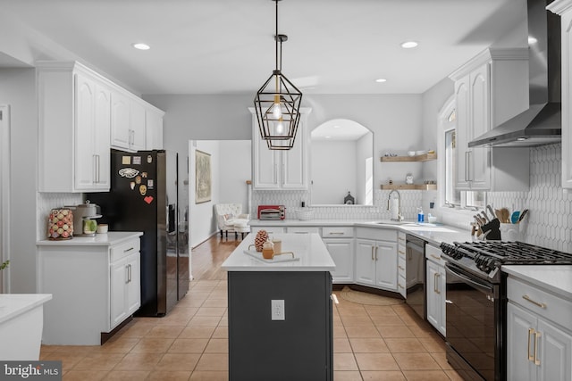 kitchen with white cabinets, wall chimney exhaust hood, stainless steel appliances, and backsplash