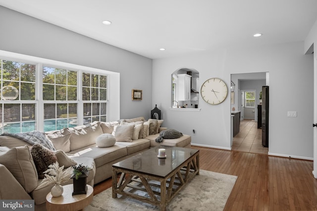 living area featuring wood-type flooring, baseboards, and recessed lighting