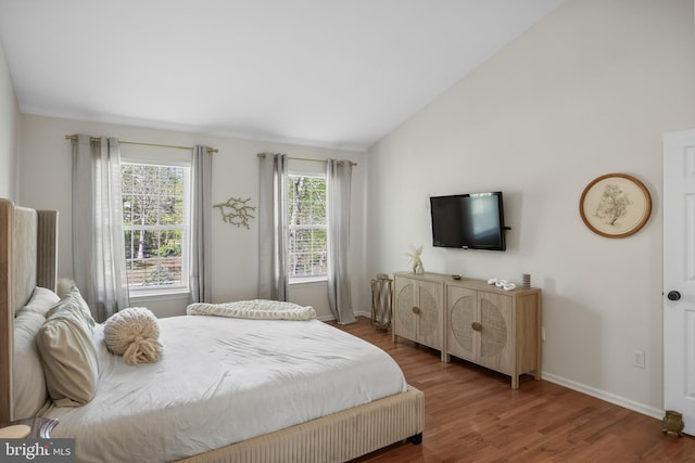 bedroom featuring vaulted ceiling, wood finished floors, and baseboards