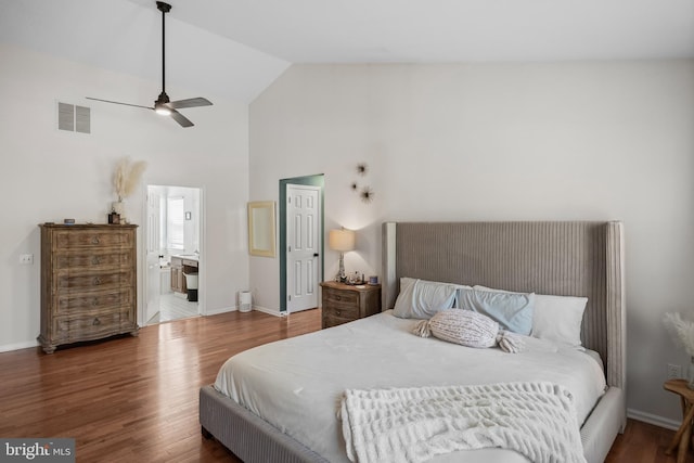 bedroom with baseboards, ensuite bathroom, visible vents, high vaulted ceiling, and wood finished floors