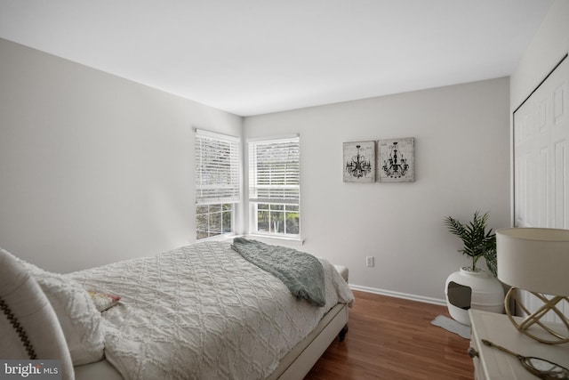 bedroom with baseboards, a closet, and wood finished floors