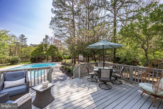 wooden terrace with a fenced backyard, a fenced in pool, and outdoor dining space