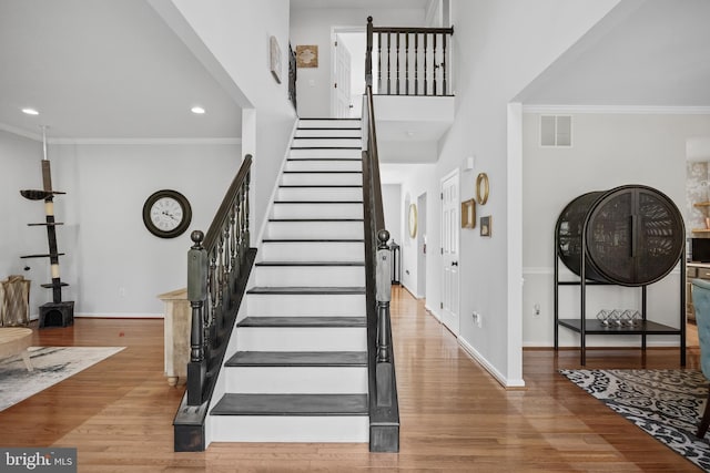 entryway featuring baseboards, stairway, visible vents, and wood finished floors