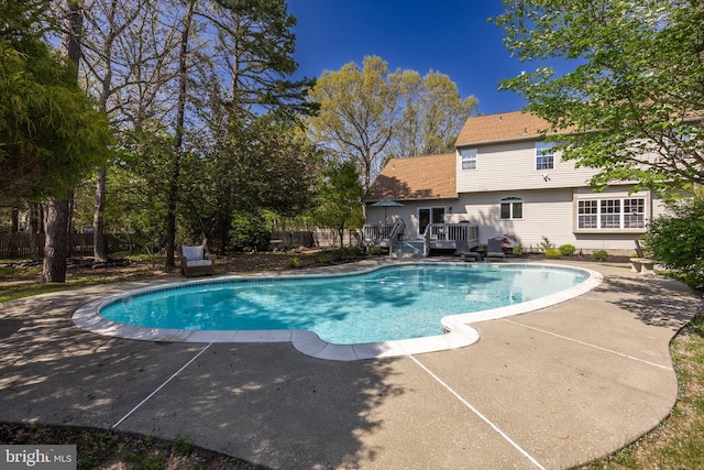 view of pool featuring a patio, a deck, fence, and a fenced in pool