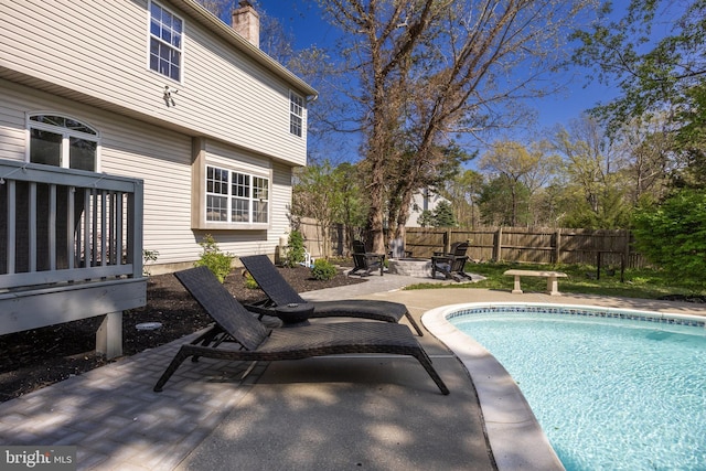 view of pool with a fenced backyard, a patio area, a fenced in pool, and a fire pit
