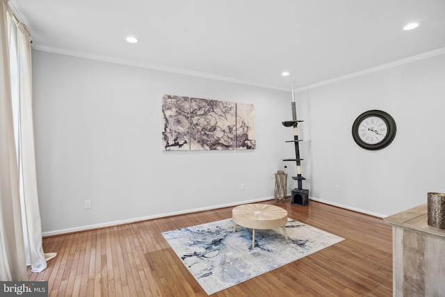 living area with baseboards, ornamental molding, and hardwood / wood-style flooring
