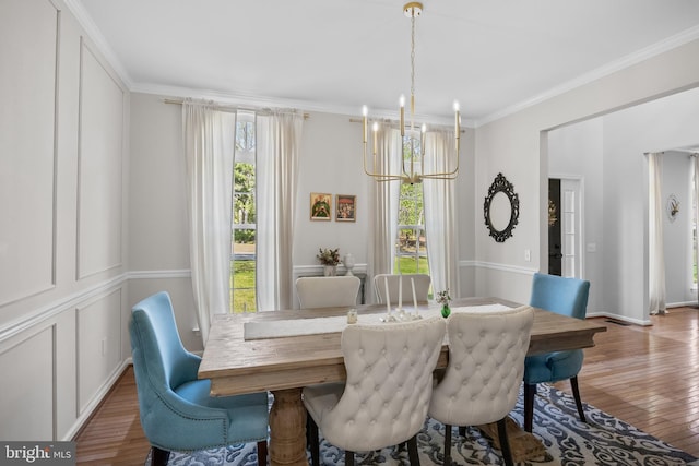 dining room featuring crown molding, plenty of natural light, wood finished floors, and a notable chandelier