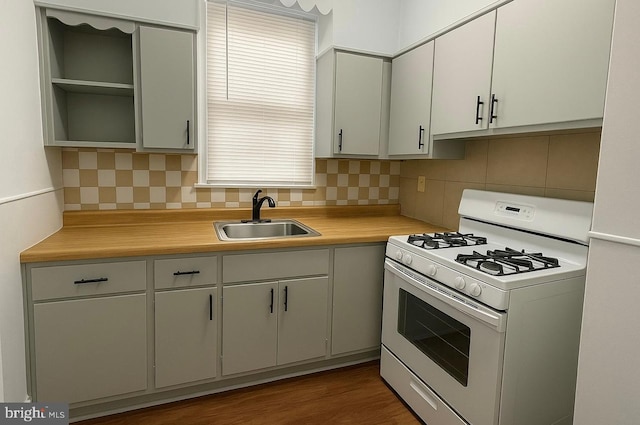 kitchen featuring a sink, tasteful backsplash, open shelves, light countertops, and white gas stove