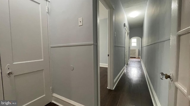 corridor with baseboards and dark wood-style flooring