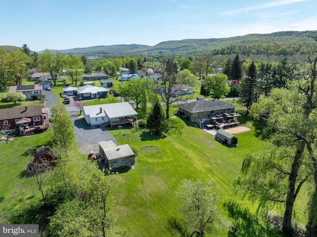 aerial view of residential area with a mountain backdrop and a heavily wooded area