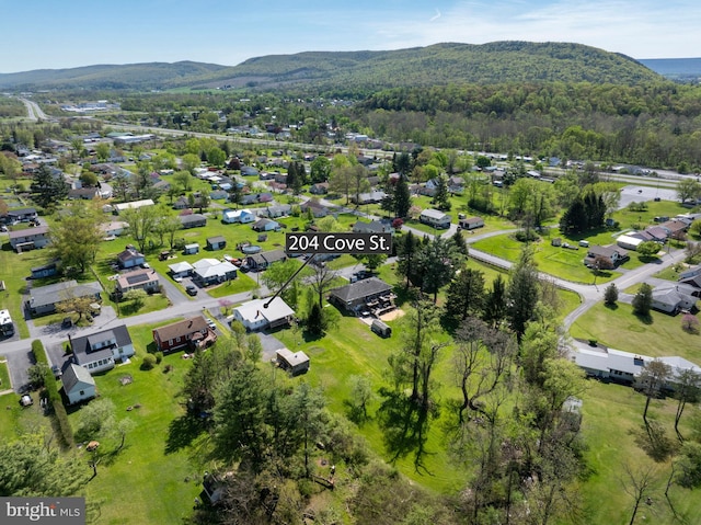 drone / aerial view with a view of trees, a mountain view, and a residential view