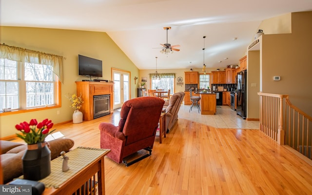 97 Heverly Ln, Beech Creek, PA 16822 - living room featuring lofted ceiling, a ceiling fan, baseboards, a glass covered fireplace, and light wood-type flooring