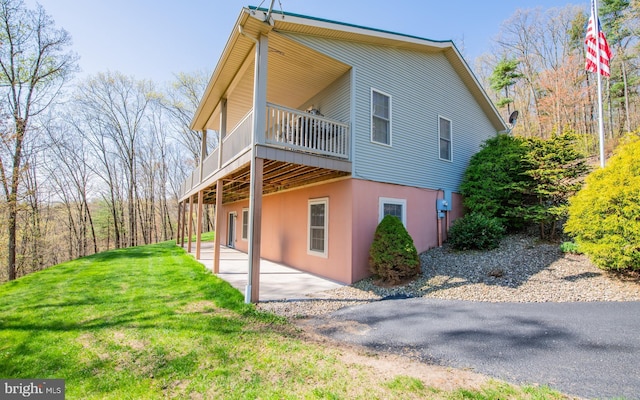 97 Heverly Ln, Beech Creek, PA 16822 - view of side of home featuring a yard, a patio area, stucco siding, and a deck