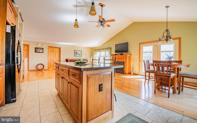 97 Heverly Ln, Beech Creek, PA 16822 - kitchen featuring lofted ceiling, freestanding refrigerator, light tile patterned flooring, a fireplace, and ceiling fan