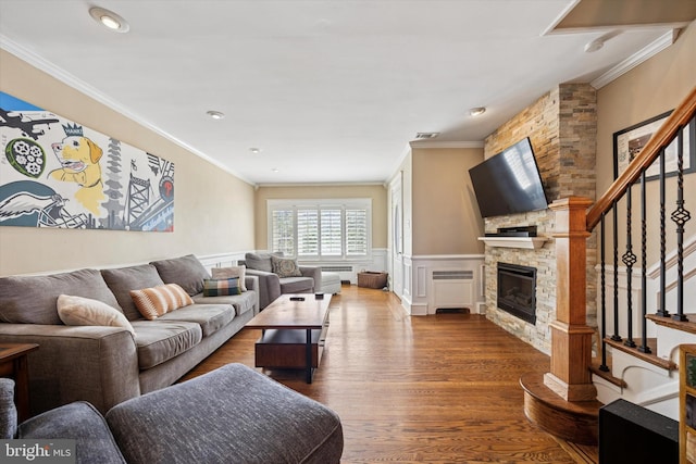 2935 S 13th St, Philadelphia, PA 19148 - living area with crown molding, a stone fireplace, dark wood-style flooring, stairway, and wainscoting