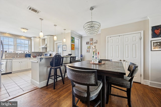 2935 S 13th St, Philadelphia, PA 19148 - dining room with a chandelier, crown molding, light wood-style floors, and baseboards